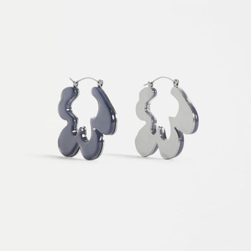 Pair of silver hoop earrings with an abstract shape on a white background.