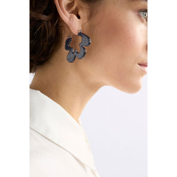 Pair of silver hoop earrings with an abstract shape on a white background.