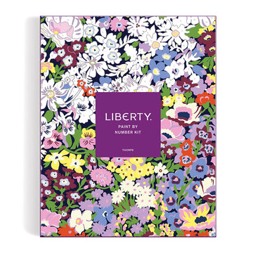 Front of a paint by numbers kit showing an almost completed painting of flowers with a purple square in the middle with the box title.