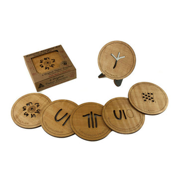 A set of six round timber coasters each with a different Aboriginal symbol cut out of it.
