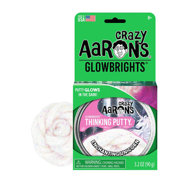 A round silver tin inside a green packet with the heading 'Crazy Aarons Glowbrights'. There white glittery putty behind the packet.