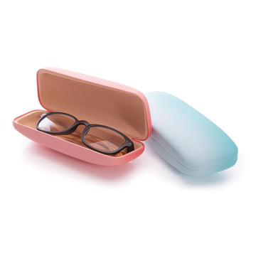Three closed hard shell glasses cases in purple, coral pink and blue.