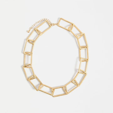 Gold geometric necklace on a white background
