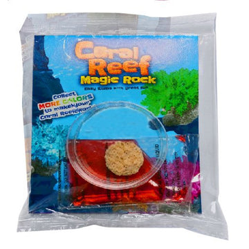 A white packet with the title 'Coral Reef Magic Rock' with photos of coloured reefs growing out of rocks. The contents of the packet are also shown on top of the packaging with a small rock in a clear round container and a packet of red dye.