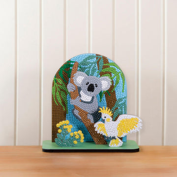 A box titled 'Koala Diamond Art' with a photo of a koala in a tree surrounded by plants and a cockatoo all covered with sparkles.
