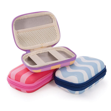 Three hard shell travel cases pictured with zip closures and each printed with a different pattern and colour.