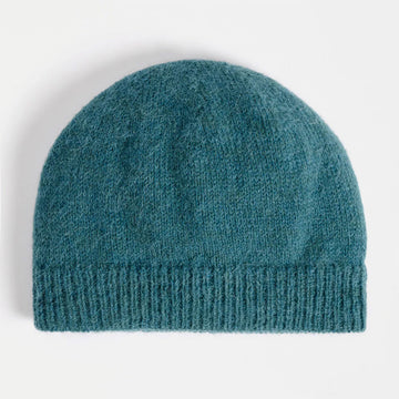 Teal knit beanie on a light gray background.