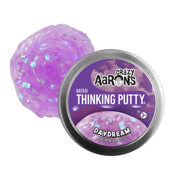 A silver tin with the heading 'Crazy Aarons Mini Thinking Putty Daydream' with purple putty behind.
