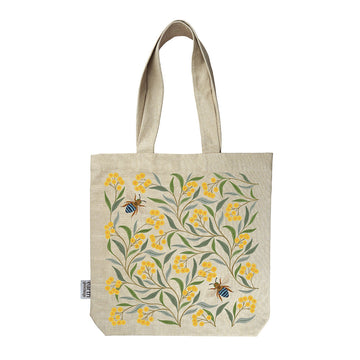 A calico tote bag printed with an illustration of wattle flowers, leaves and bees.