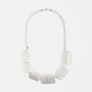 Silver necklace with textured design on a white background.