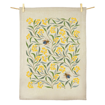 A cotton tea towel illustrated with wattle flowers and bees.