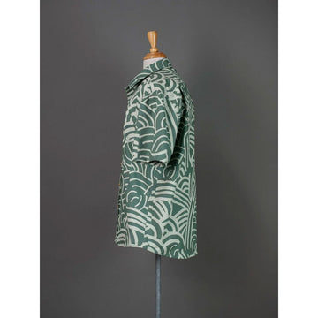 Front view of a green patterned shirt on a mannequin against a gray background.