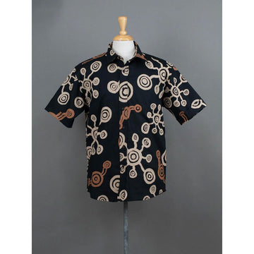 Front view of a black shirt with circular pattern on a mannequin against a gray background.