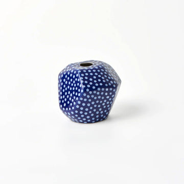 A hexagon shaped vase in blue with light blue spots.