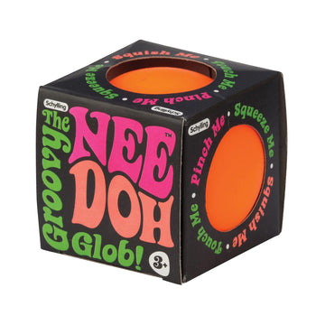 An orange stress ball inside a cube box with round cut outs. The box says 'The Groovy Glob! Nee Doh' on the front and 'Pinch Me Squeeze Me Squish Me Touch Me' on the side and top.