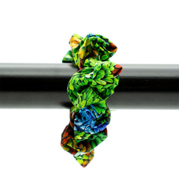 Colourful scrunchie on a black bar against a white background.