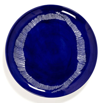 Top down view of a blue ceramic plate printed with white stripes around the edges.
