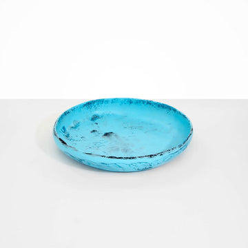 A large round shallow bowl made from blue resin.