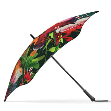 An open umbrella standing up and printed with birds and flowers.