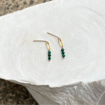 A pair of gold earrings with malachite beads.