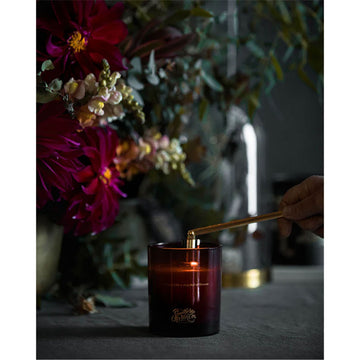 Black candle cylinder packaging with floral design and 'Southern Wild Co' branding next to a red candle with the same branding.