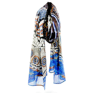 A cotton scarf printed with artwork by Bianca Gardiner Dodd in blue, orange, black and white.