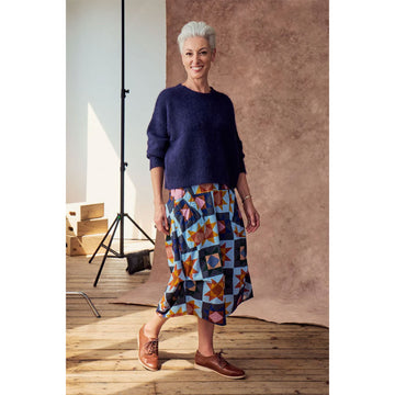 A skirt printed with a star pattern in yellow and blue with side pockets and side tucks.