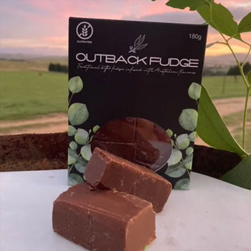 An image of fudge on a able with some eucalypt nuts and a farm scene in the background.
