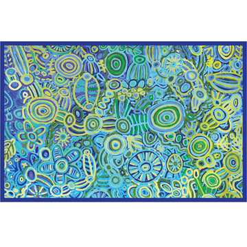 A table cloth is laying flat and printed with artwork by Cedric Varcoe in blue and green.