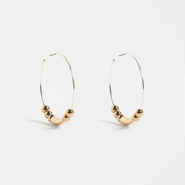 Silver hoop earrings with bead embellishments on a white background