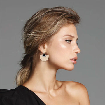 Two pairs of earrings pictured, one with hooks and Xs and the other with hoops and a bell shape.