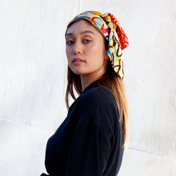 A silk scarf printed with artwork by Tommy May.