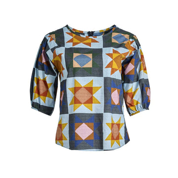 A women's blouse printed with a star pattern in yellow and blue.