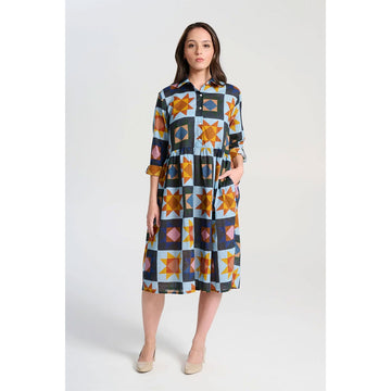 A long sleeve shirt dress with a gathered waist and printed with a star pattern in blue and yellow.