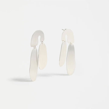 Pair of silver earrings on a light gray background.