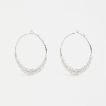 Pair of silver hoop earrings on a light gray background.