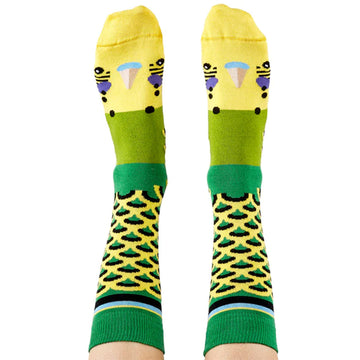 A pair of tall socks as shown on a person's legs and feet featuring green budgie faces on them.
