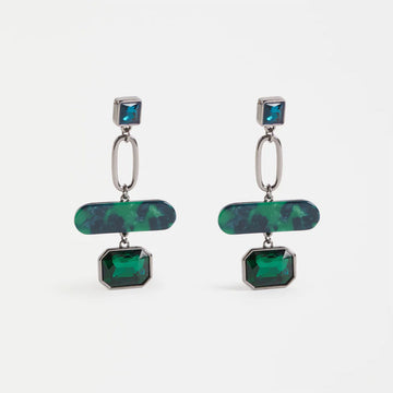 Pair of earrings with green and blue gemstones on a white background.
