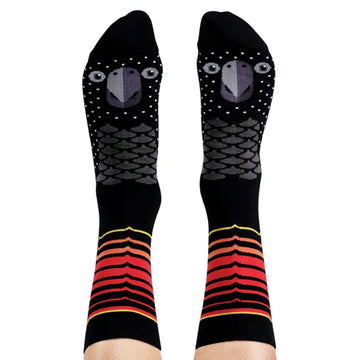 A pair of tall socks as shown on a person's legs and feet illustrated with the face of a black cockatoo.