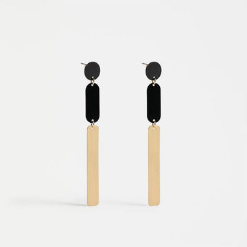 Pair of earrings with black circular tops and gold bars on a white background.