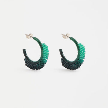 Green beaded hoop earrings on a white background.