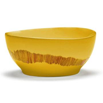 Side view of a ceramic bowl in yellow with red stripes around the bottom edge.