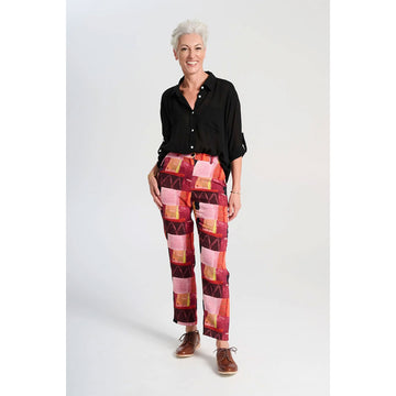 A pair of women's pants printed with a red and pink rectangle pattern.