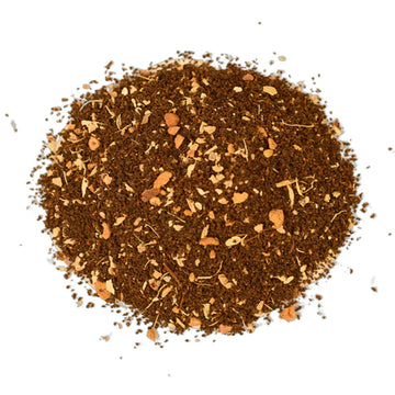 An image of a brown tea box with white writing sitting behind some spices.