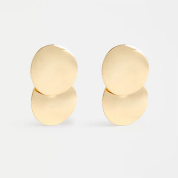 Pair of round gold earrings on a light gray background.