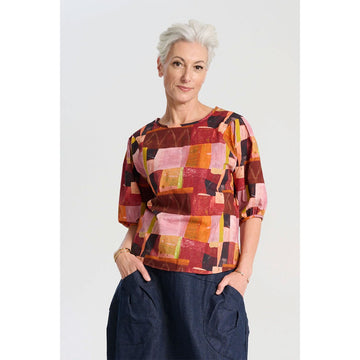 A women's blouse printed with a red and pink rectangle pattern.