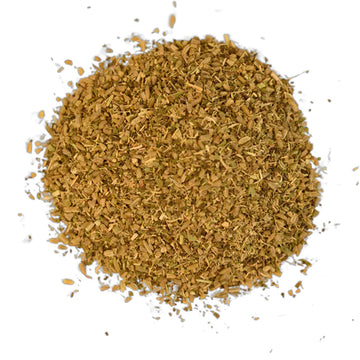 A light brown tea box with white writing  sitting behind a bowl of ground spices, some seeds, nuts and mint.