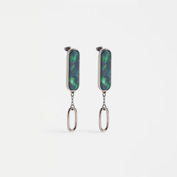 Pair of earrings with green gemstones and silver chains on a white background.