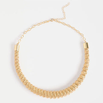 A gold necklace with zig zag shaped pattern.