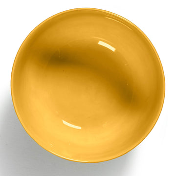 Side view of a ceramic bowl in yellow with red stripes around the bottom edge.